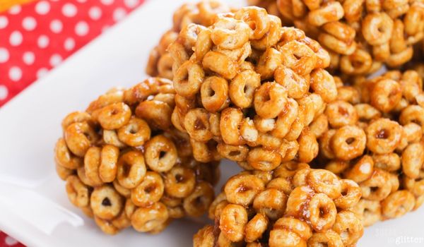 honey nut cheerio balls on a white platter on top of a red polka dot napkin