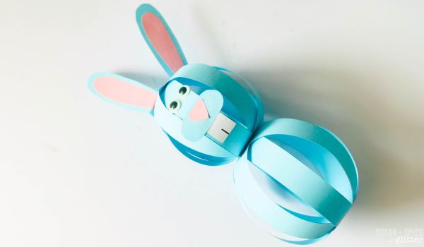 overhead shot of a blue paper bally bunny craft with googly eyes and a pink nose