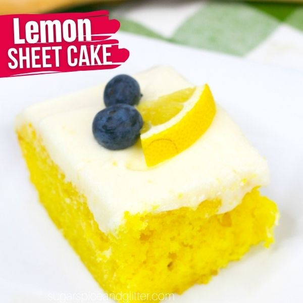 a square of lemon sheet cake on a white plate set on a green plaid napkin